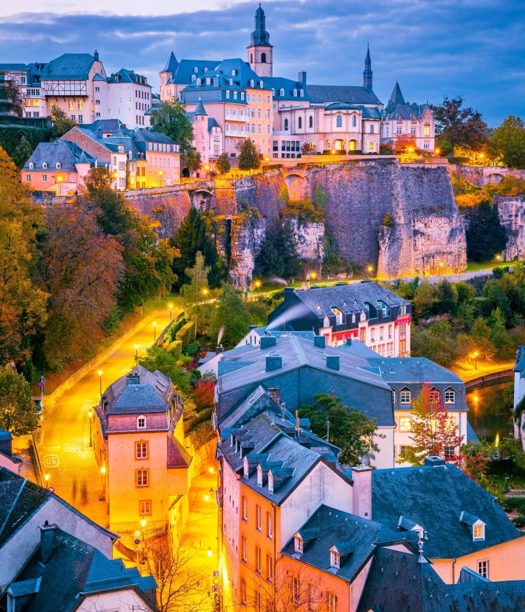 Een luchtfoto van de stad Luxemburg bij schemering 