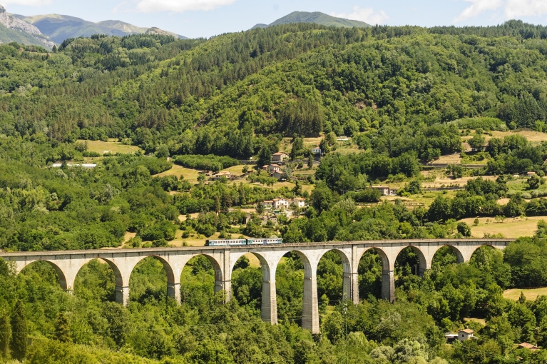 Een trein rijdt over een brug in het hart van Toscane