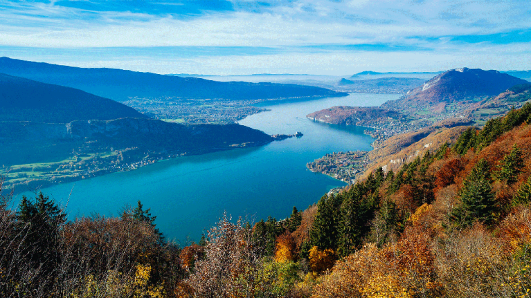 A mountaintop view of water and autumnal trees outside of Annecy, France.