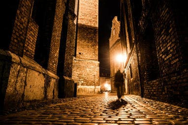 _european_halloween_destinations_-dark_blurred_silhouette_of_person_evokes_jack_the_ripper_in_illuminated_cobbled_street_in_old_historical_city_by_night_resized