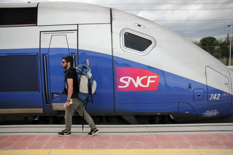 Rugzaktoerist die naar de TGV in Figueres loopt