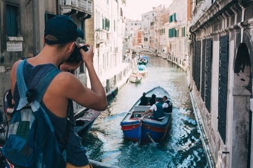 man_taking_a_photo_of_venice_canal