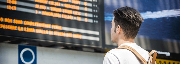 masthead-man-standig-in-front-of-departure-screen-train-station