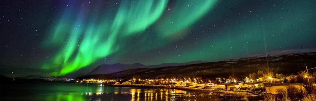 northern_lights_over_a_beautiful_small_village_in_norway_desktop