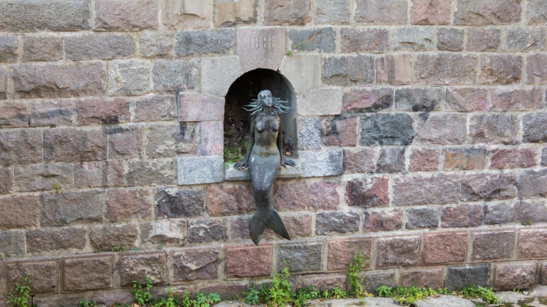 lithuania-vilnius-mermaid-statue-sitting-by-river