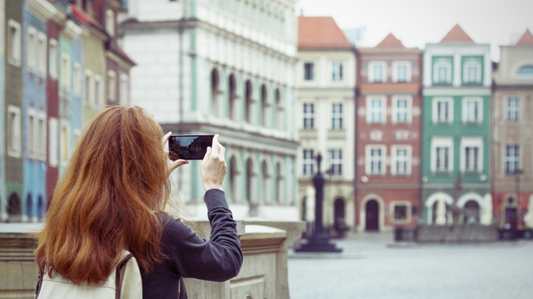 poland-poznan-square-colorful-buildings-woman-taking-picture