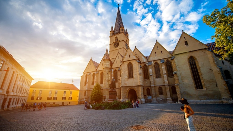 romania-sibiu-lutheran-cathedral-sunset-woman