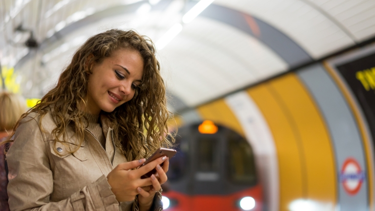 Woman checking the Rail Planner app in the London Underground