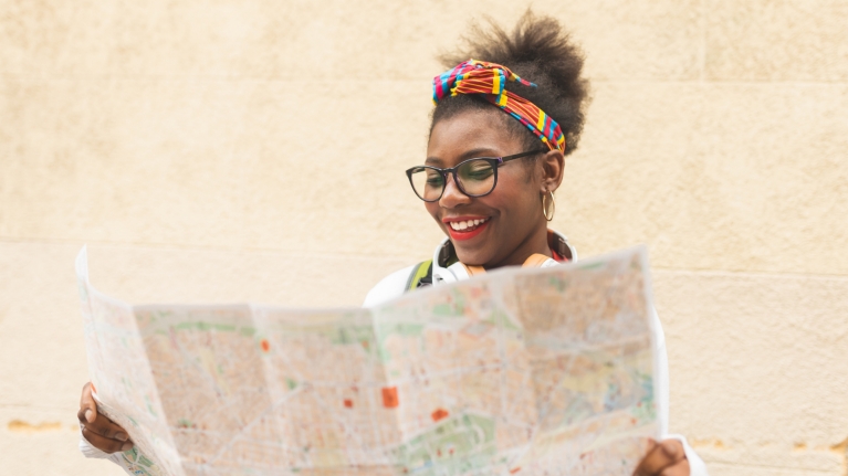 Woman planning her Interrail trip with a city map 