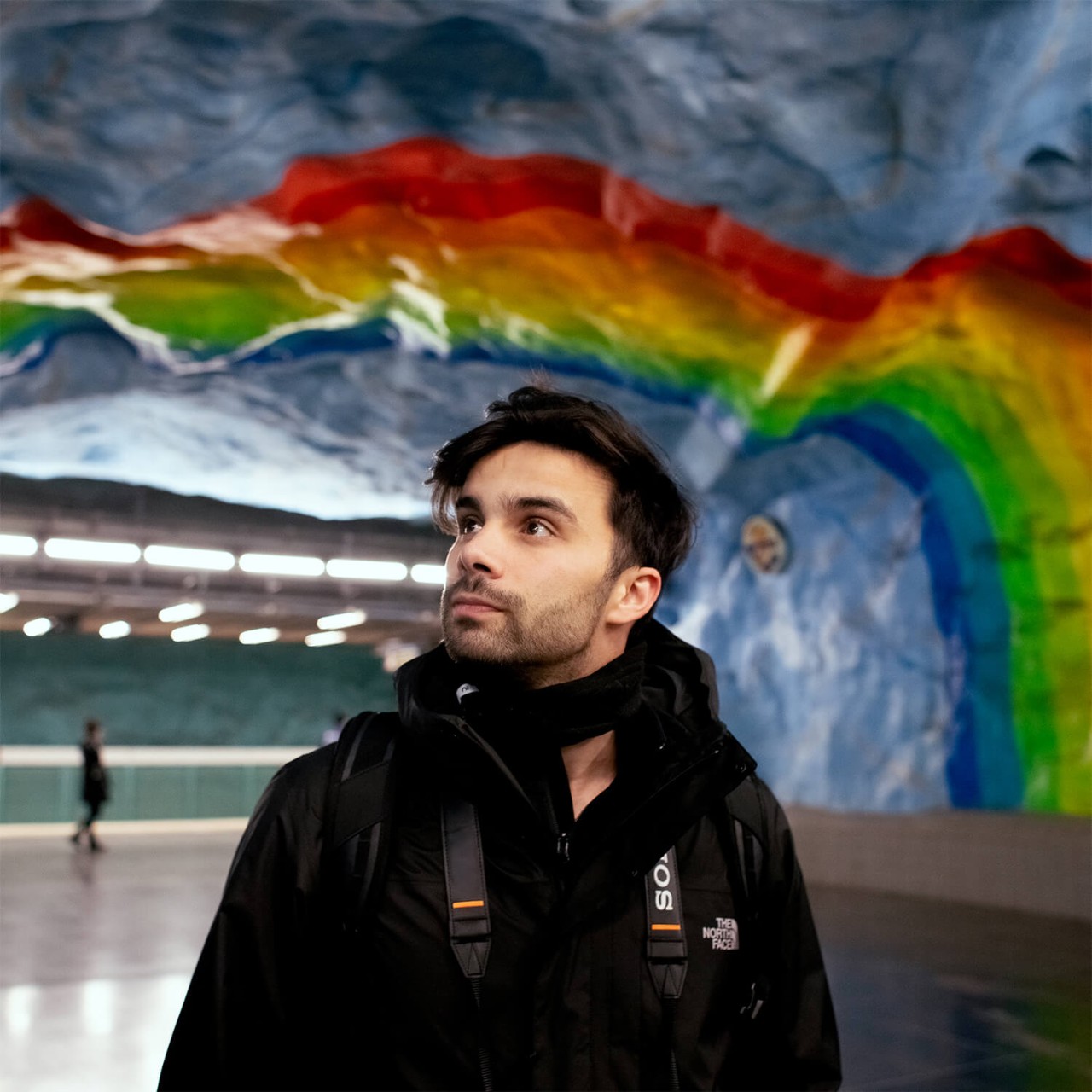 Eine Person bewundert farbenfrohe Kunst in einer U-Bahnstation in Stockholm