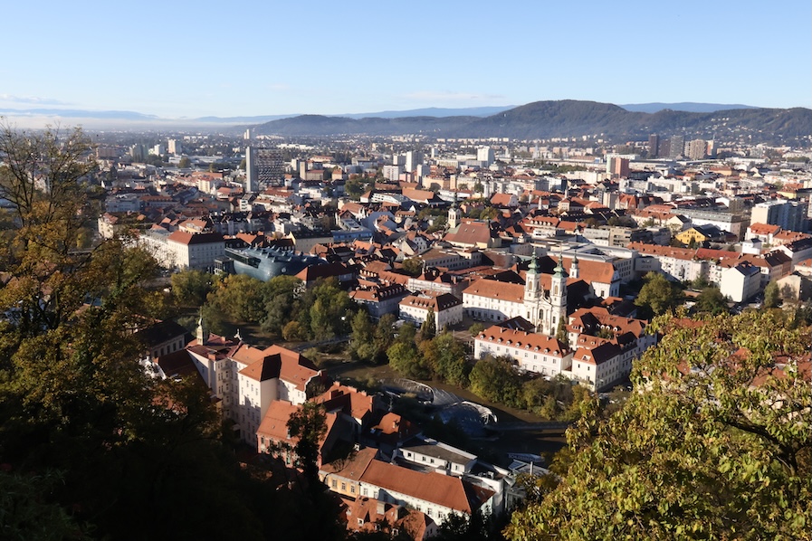 A bird's eye view of Graz's red-roofed buildings and trees
