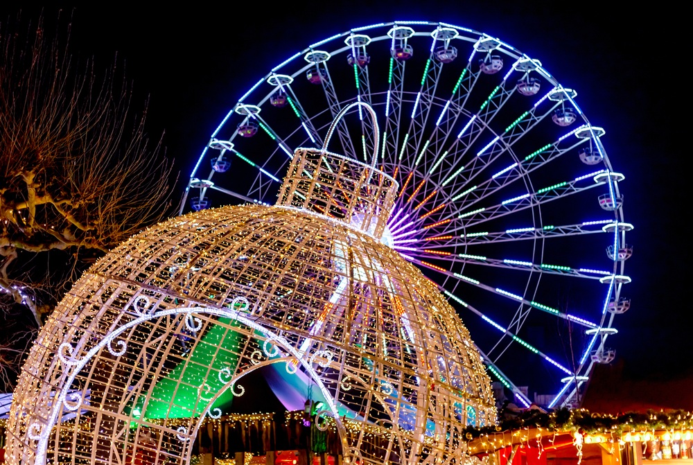 Giant Christmas ball and Ferris wheel. Christmas fair in Maastricht, Netherlands. New Year decorations at Christmas market. Ferris wheel glows at night
