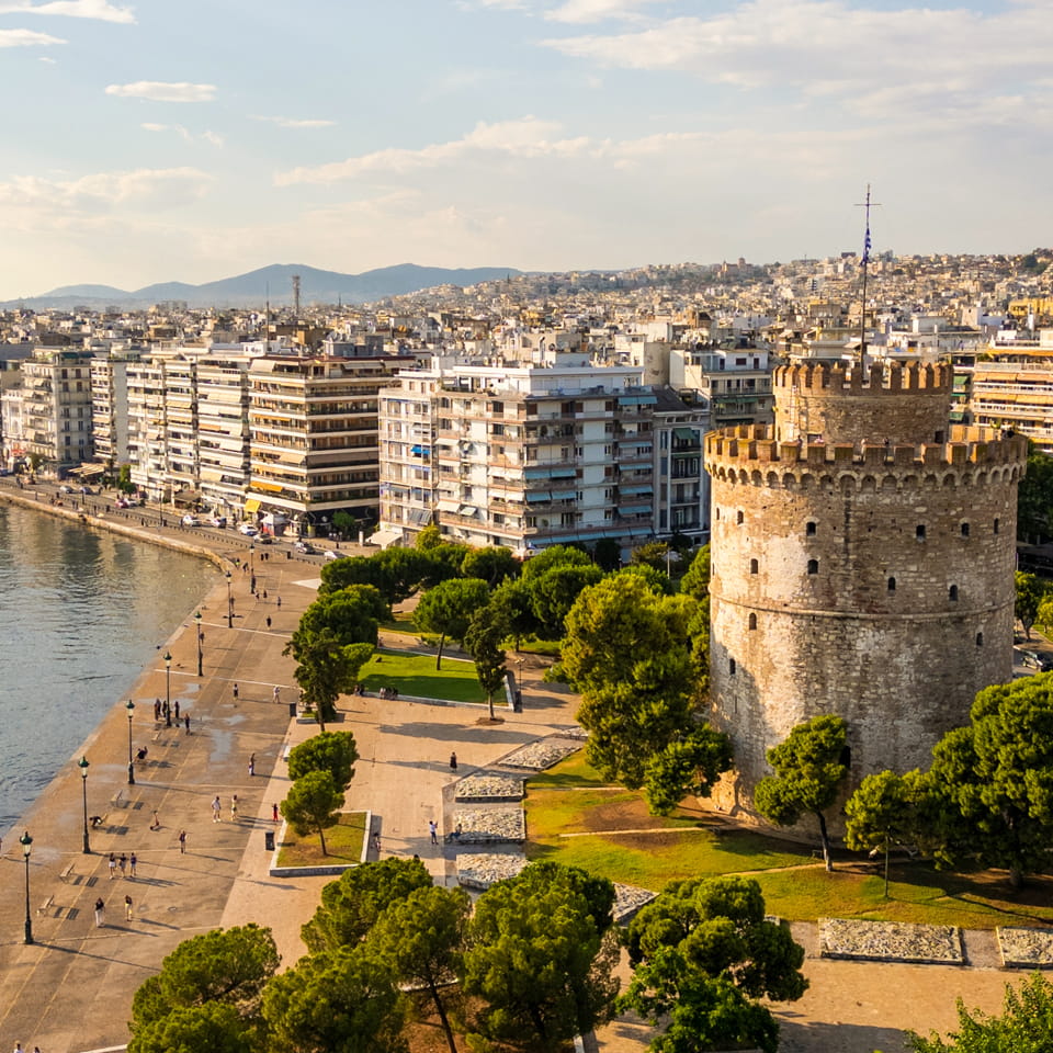 Vista aerea della Torre Bianca a Salonicco, Grecia, circondata da una rigogliosa vegetazione e dal vivace paesaggio urbano | Cosa fare a Salonicco, Grecia