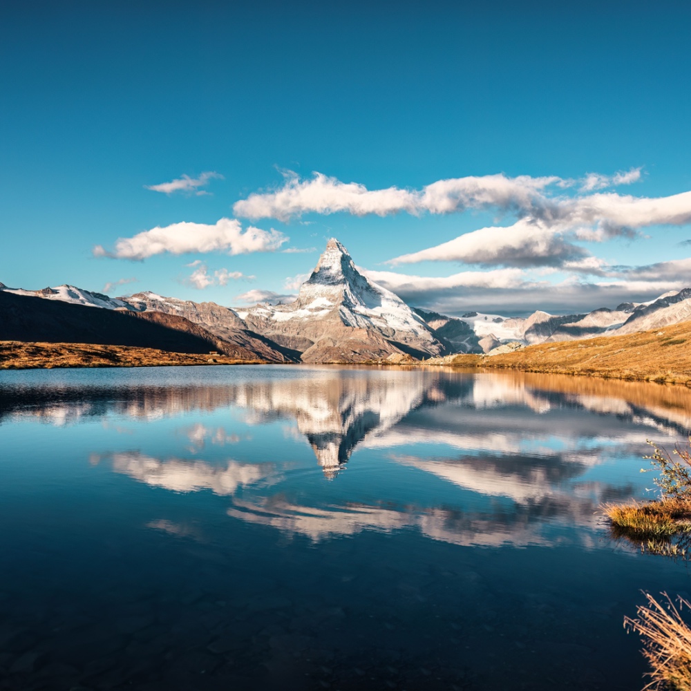 Una vista di un lago alpino con la vetta aguzza del Cervino riflessa sulla superficie